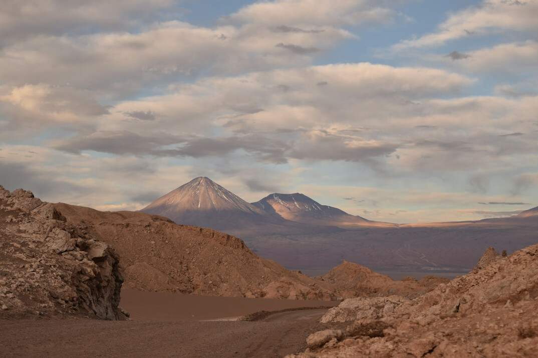 Atacama desert salt flat at dusk with distant volcanoes
