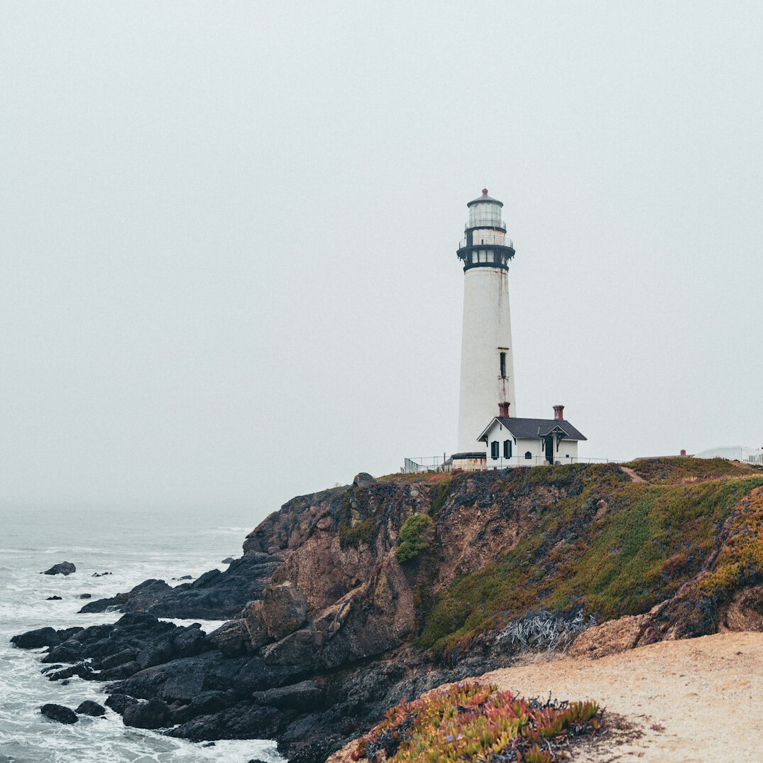 Abandoned lighthouse on the southern coast of Chile covered in fog at dusk