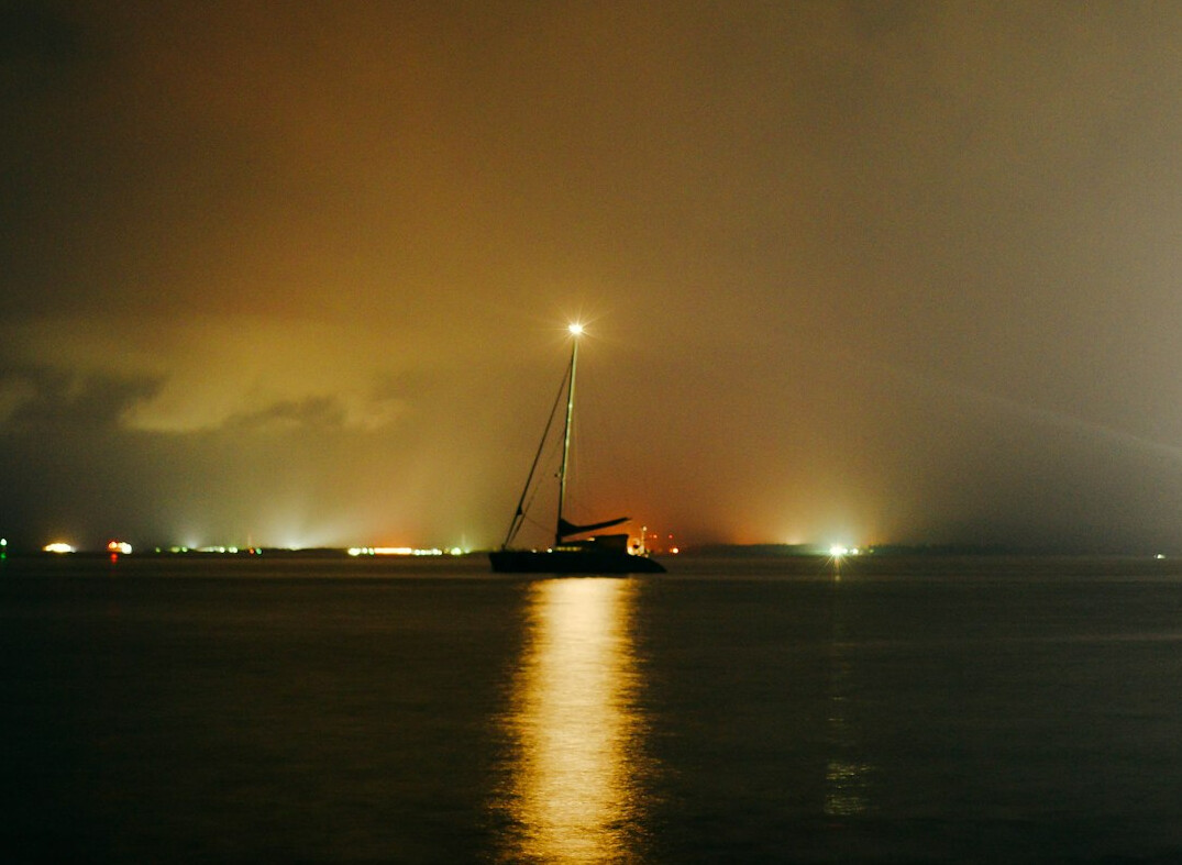 Ghostly sailing ship glowing in fog on a night sea