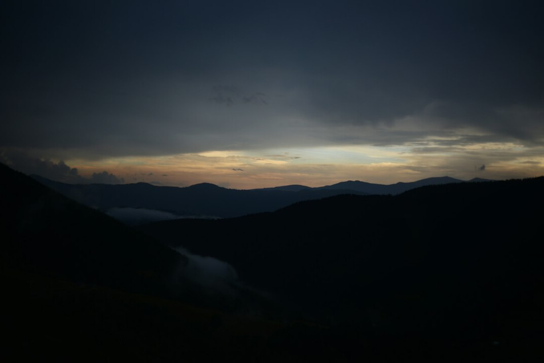 Unexplained lights in a night sky above a dark valley